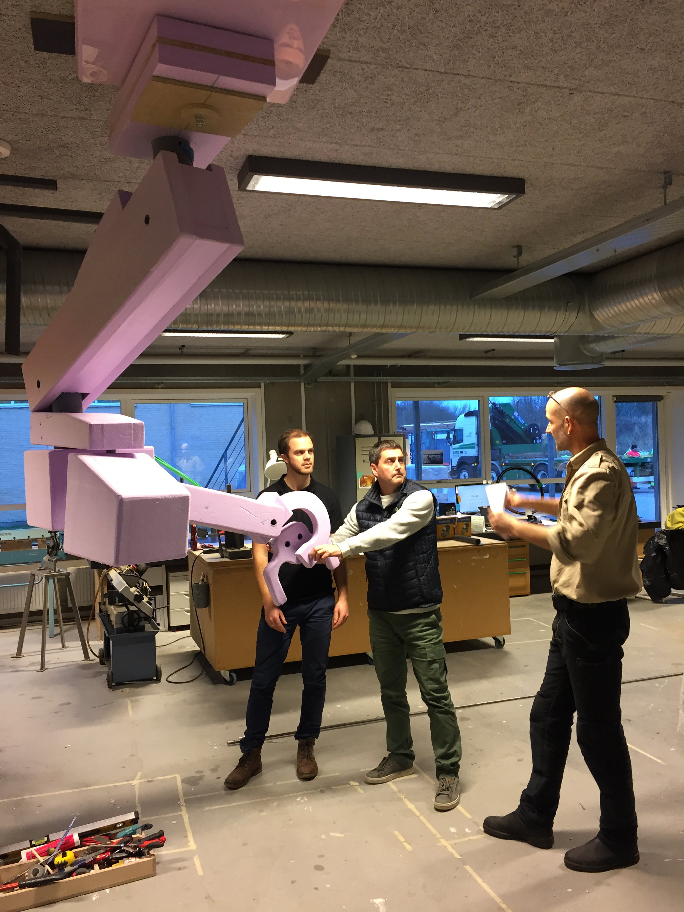 Three men are testing the prototype of the ceiling-mounted microscope
